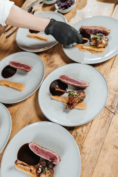 Chef preparing multiple plates for a dinner catering