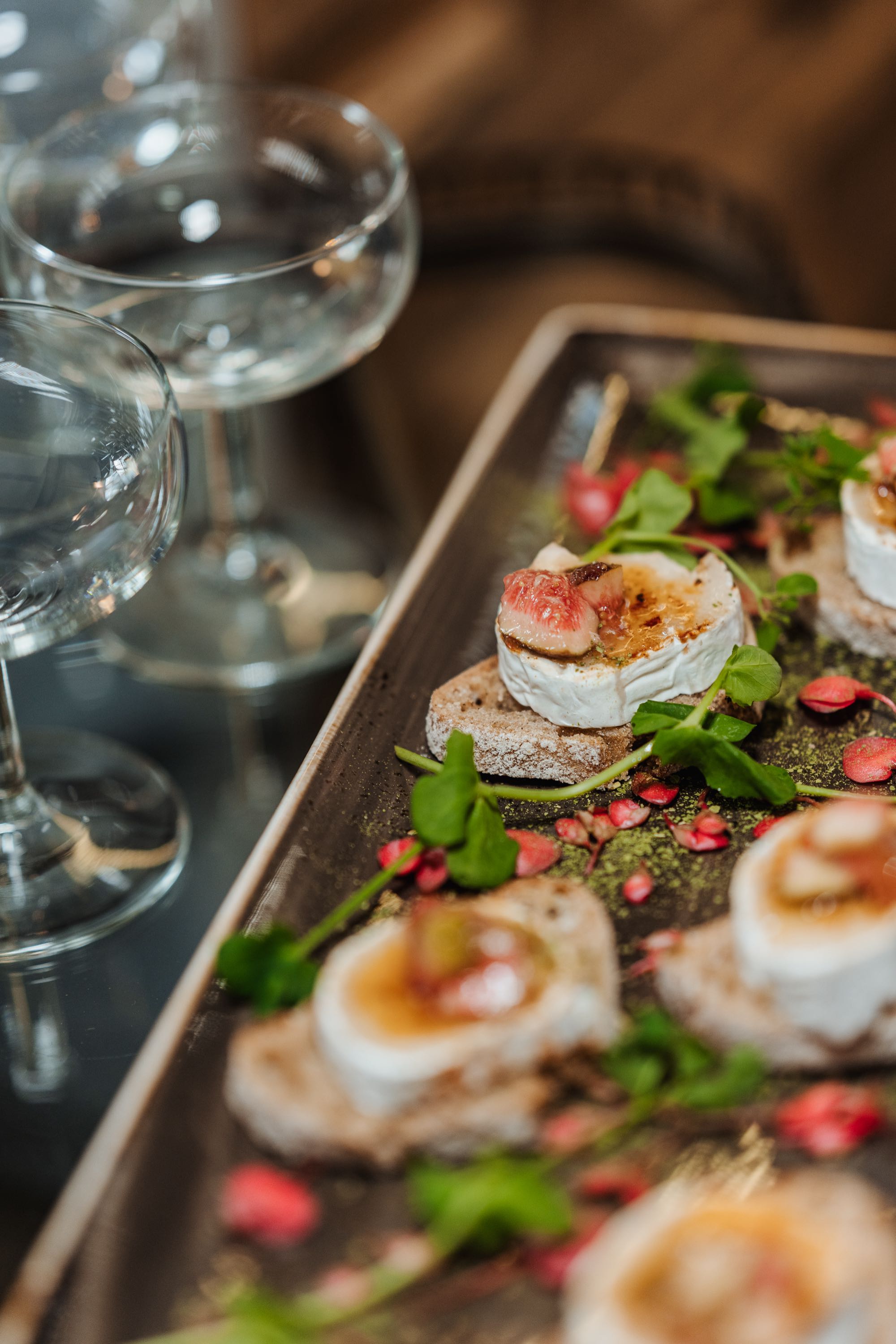 Ein Tablet mit Ziegenkäsehäppchen auf rustikalem Brot — Feine Fingerfoodvariation